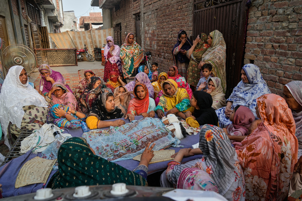 Women mourn around the bodies of their children, who were killed in the roof collapse at a tutoring center that was under construction on the outskirts of Lahore, Pakistan, Wednesday, July 1, 2026. (AP Photo/K.M. Chaudary)