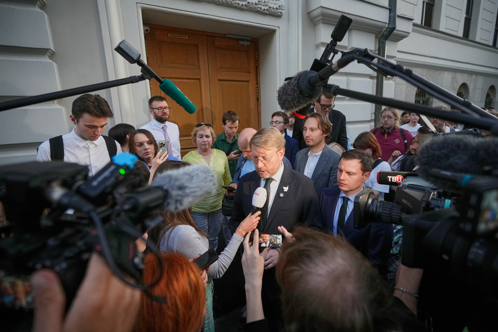 Journalists and supporters of the Yabloko party listen to Yabloko party leader Nikolai Rybakov, center, after a hearing on a lawsuit to bar the party from the upcoming parliamentary elections, at the Russia's Supreme Court, in Moscow, Monday, Aug. 10, 2026. (AP Photo/Pavel Bednyakov)