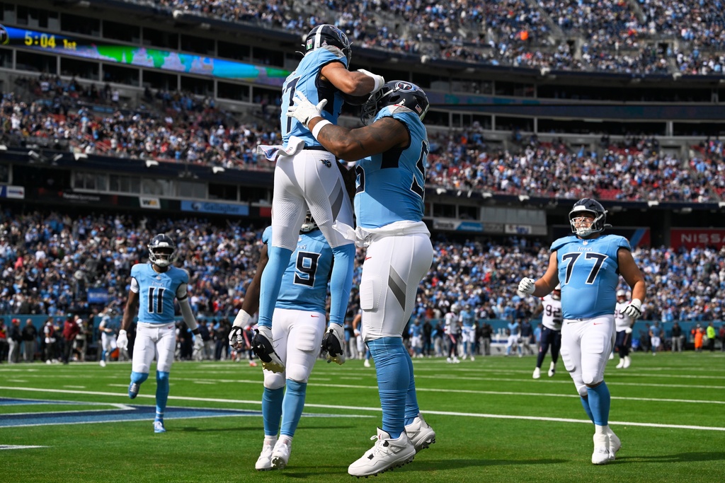 Tennessee Titans wide receiver Chimere Dike (17) celebrates a touchdown catch with offensive tackle JC Latham (55) during the first half of an NFL football game, Sunday, Oct. 19, 2025, in Nashville, Tenn. (AP Photo/John Amis)