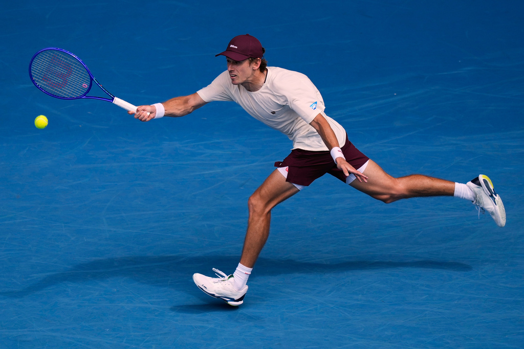 Alex de Minaur of Australia plays a forehand return to Mackenzie McDonald of the U.S. during their first round match at the Australian Open tennis championship in Melbourne, Australia, Monday, Jan. 19, 2026. (AP Photo/Aaron Favila)