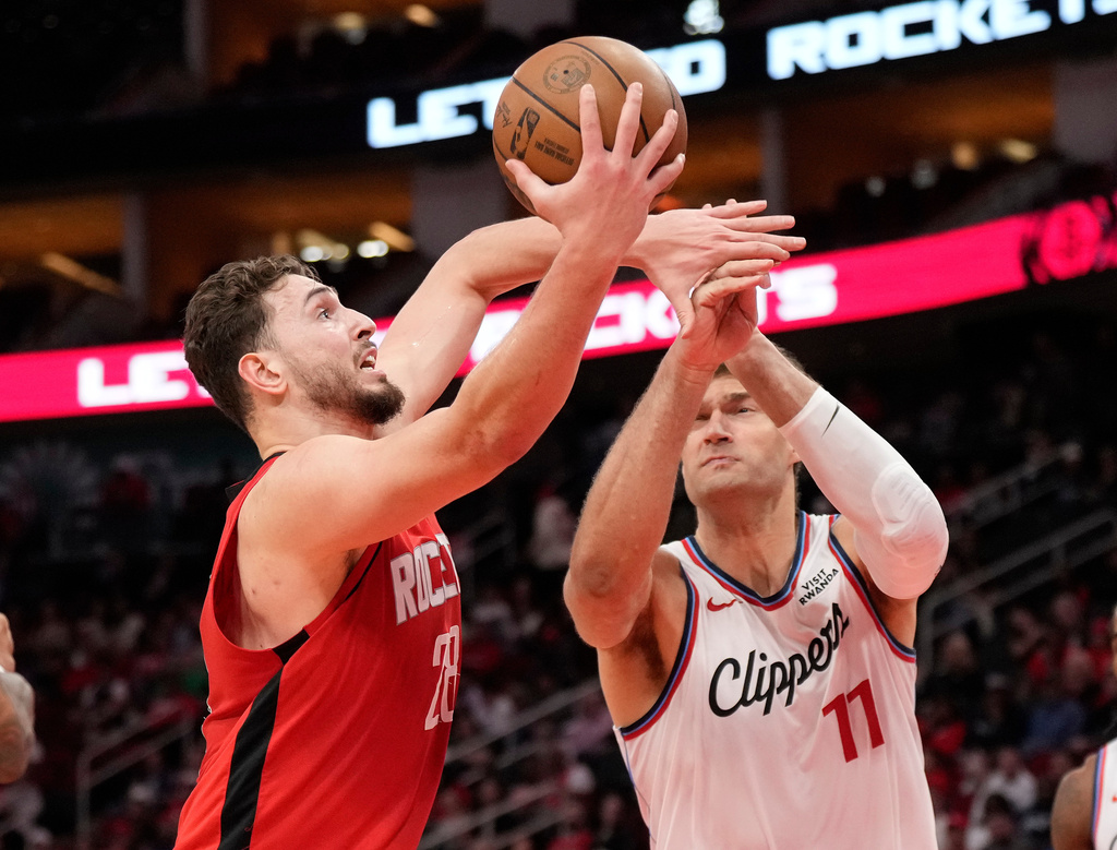 Houston Rockets center Alperen Sengun (28) and Los Angeles Clippers center Brook Lopez (11) reach for the rebound during the first half of an NBA basketball game, Tuesday, Feb. 10, 2026, in Houston. (AP Photo/ Karen Warren)