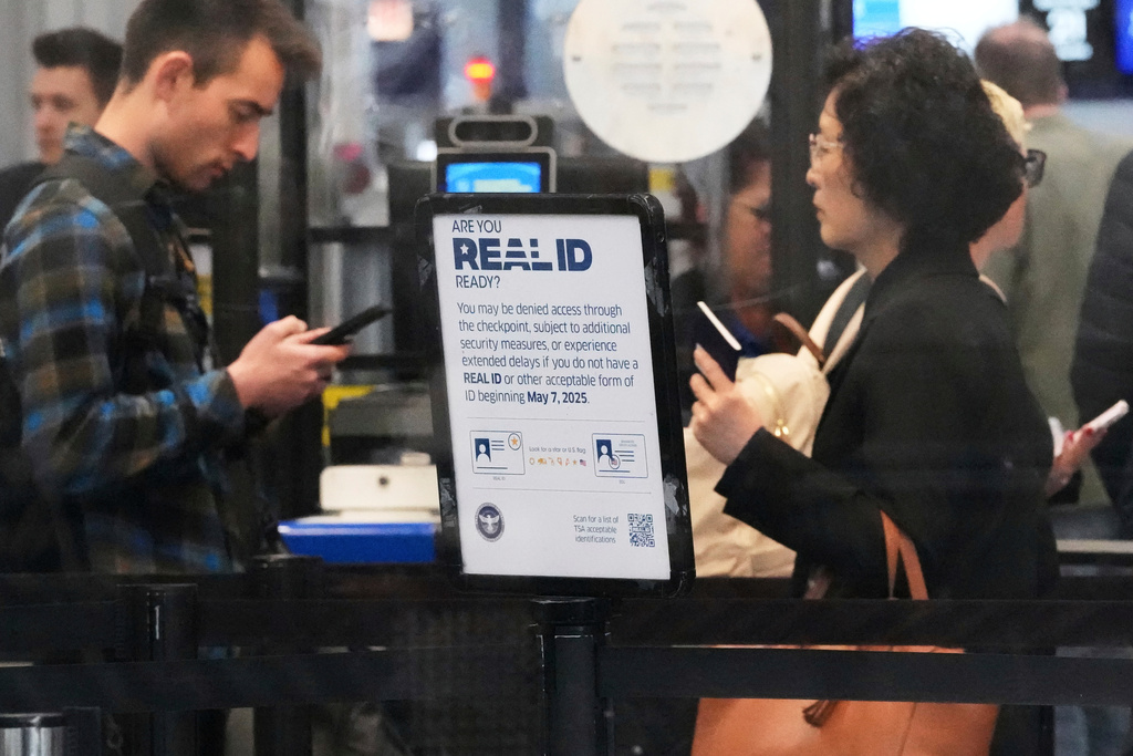 FILE - A Real ID sign is displayed as travelers wait to go through security check point at O'Hare International Airport in Chicago, May 23, 2025. (AP Photo/Nam Y. Huh, File)