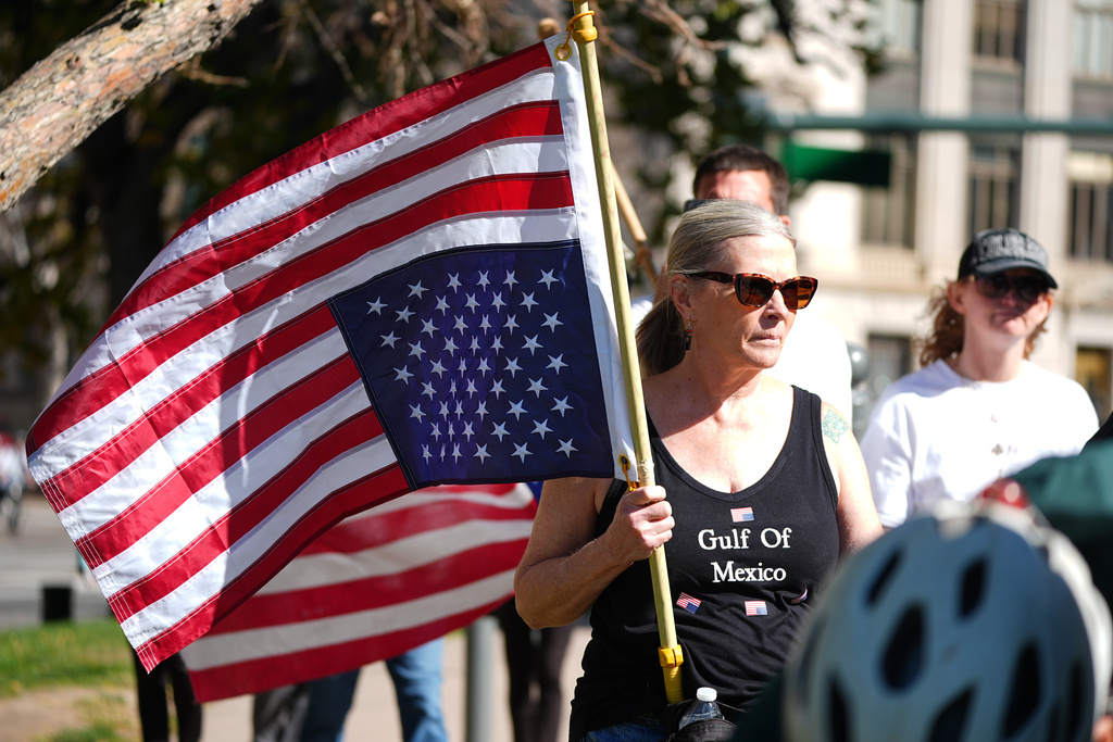 FILE - A person holds an American flag upside-down during a "No Kings" protest Oct. 18, 2025, in Denver. (AP Photo/David Zalubowski, File)