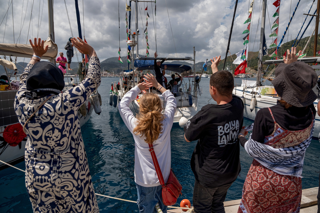 People wave to boats belonging to the Global Sumud Flotilla, carrying activists and humanitarian aid, depart for Gaza from the port of Marmaris, Turkey, Thursday, May 14, 2026, in an attempt to break the Israeli naval blockade. (AP Photo/Murat Kocabas)
