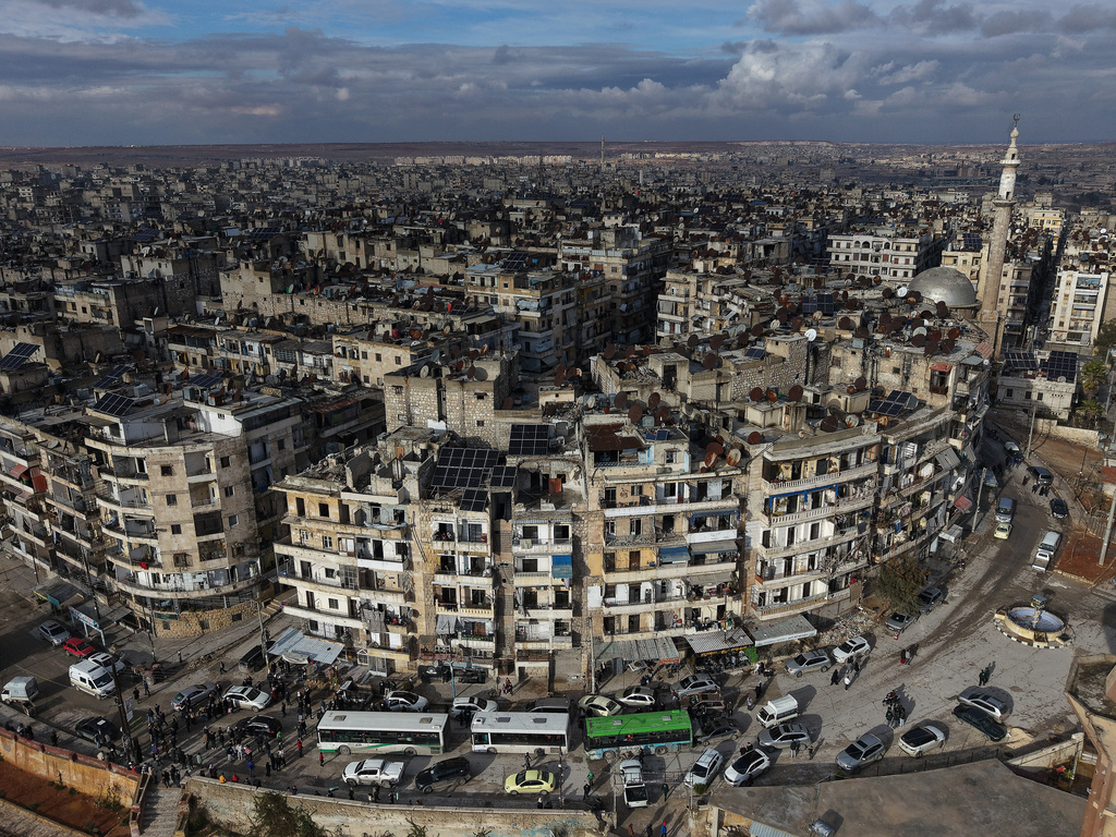 FILE - An aerial view shows buses carrying displaced residents as they return to the Sheikh Maqsoud neighborhood after days of fighting between government forces and Kurdish fighters in the northern city of Aleppo, Syria, Tuesday, Jan. 13, 2026. (AP Photo/Omar Albam)