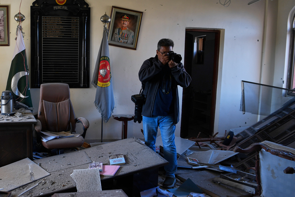 A photographer takes a picture of a damaged room of an army-run cadet college that was assaulted by militants on Monday, in Wana, a city in the northwestern Pakistani district South Waziristan bordering with Afghanistan, Thursday, Nov. 13, 2025. (AP Photo/Ahsan Shahzad)