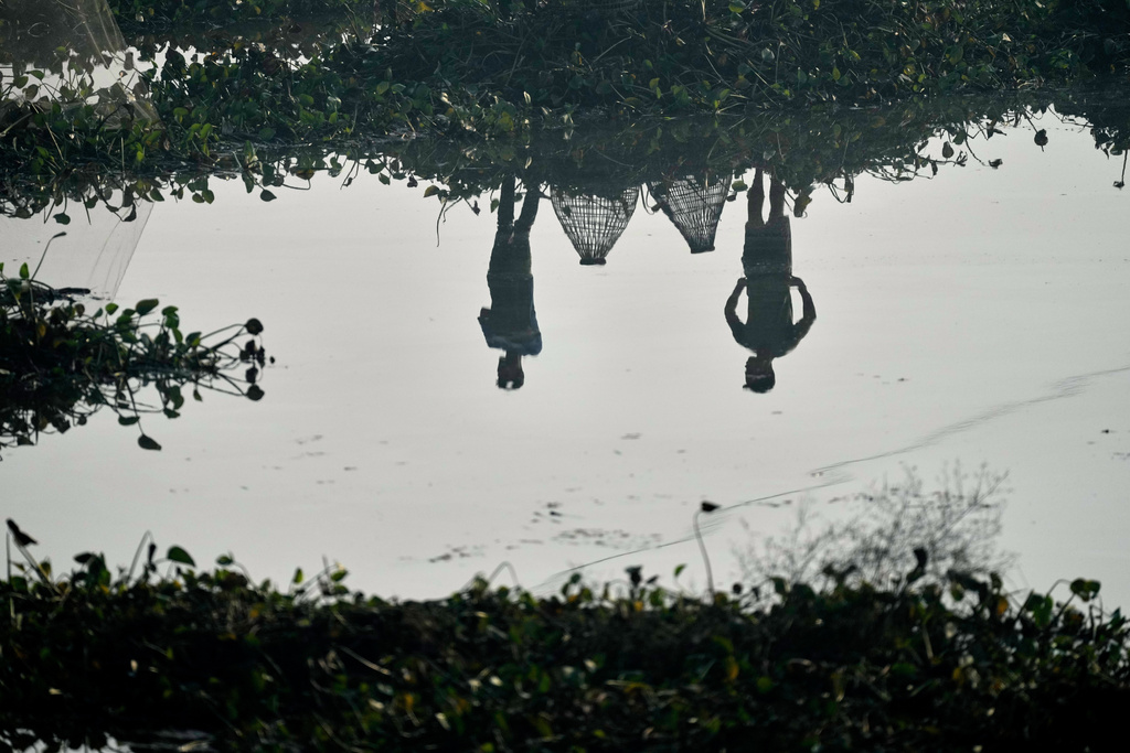 Villagers with their fishing tools wait to participate in a community fishing as part of Bhogali Bihu celebrations which mark the end of the harvest season at Jalikhora village east of Guwahati, India, Tuesday, Jan. 13, 2026. (AP Photo/Anupam Nath)