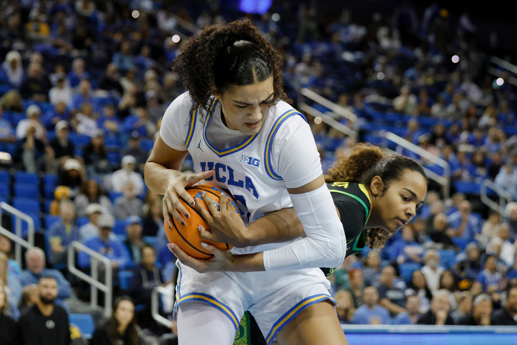 UCLA center Lauren Betts, left, protects the ball from Oregon forward Ehis Etute (35) during the first half of an NCAA college basketball game Sunday, Dec. 7, 2025, in Los Angeles. (AP Photo/Caroline Brehman)