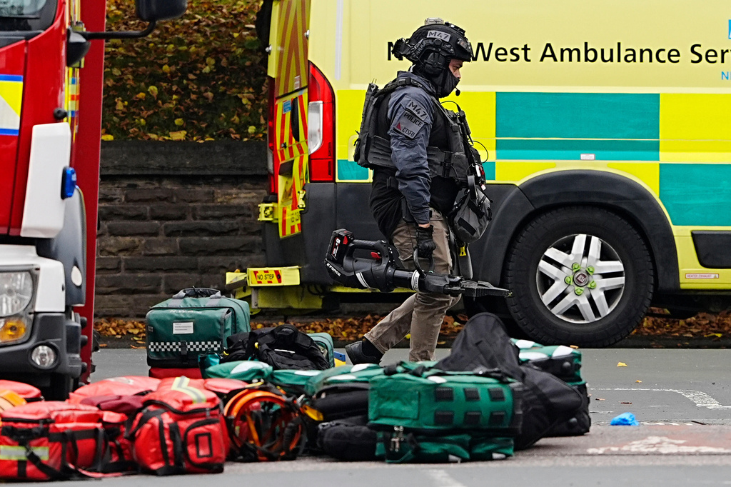 An armed officer walks at the scene of a stabbing incident at Heaton Park Hebrew Congregation synagogue, in Crumpsall, Manchester, England, Thursday Oct. 2, 2025. (Peter Byrne/PA via AP)