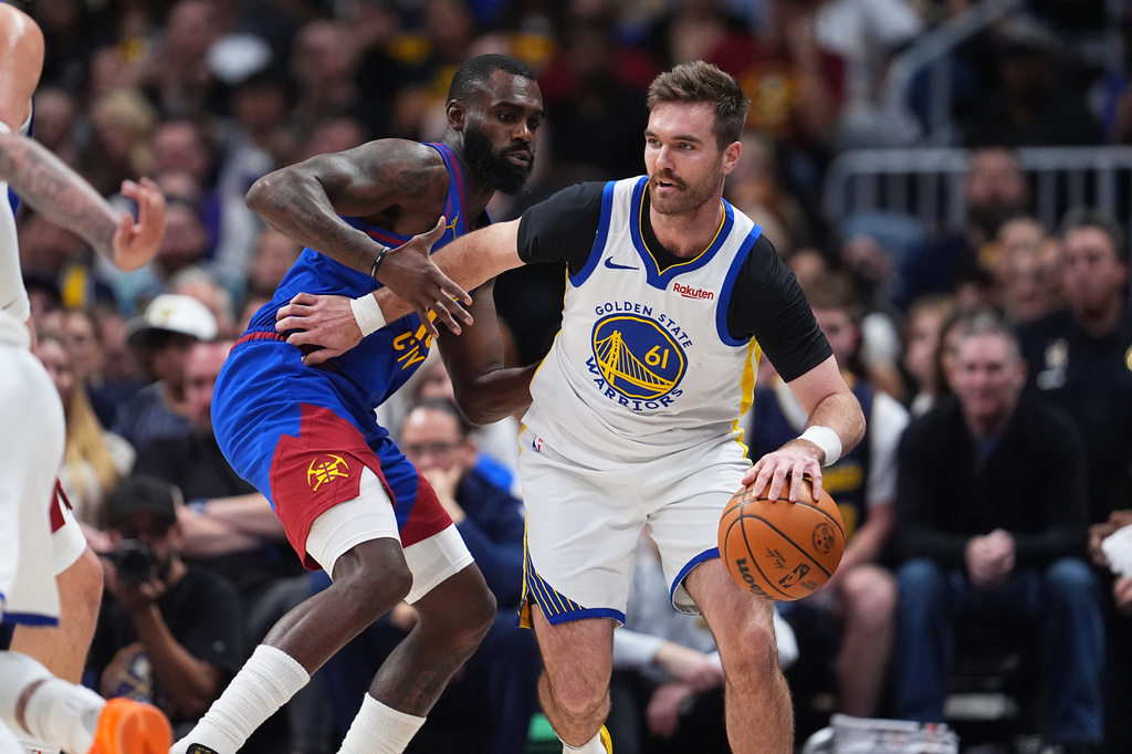 Golden State Warriors guard Pat Spencer, right, drives past Denver Nuggets guard Tim Hardaway Jr. in the first half of an NBA basketball game Sunday, March 29, 2026, in Denver. (AP Photo/David Zalubowski)