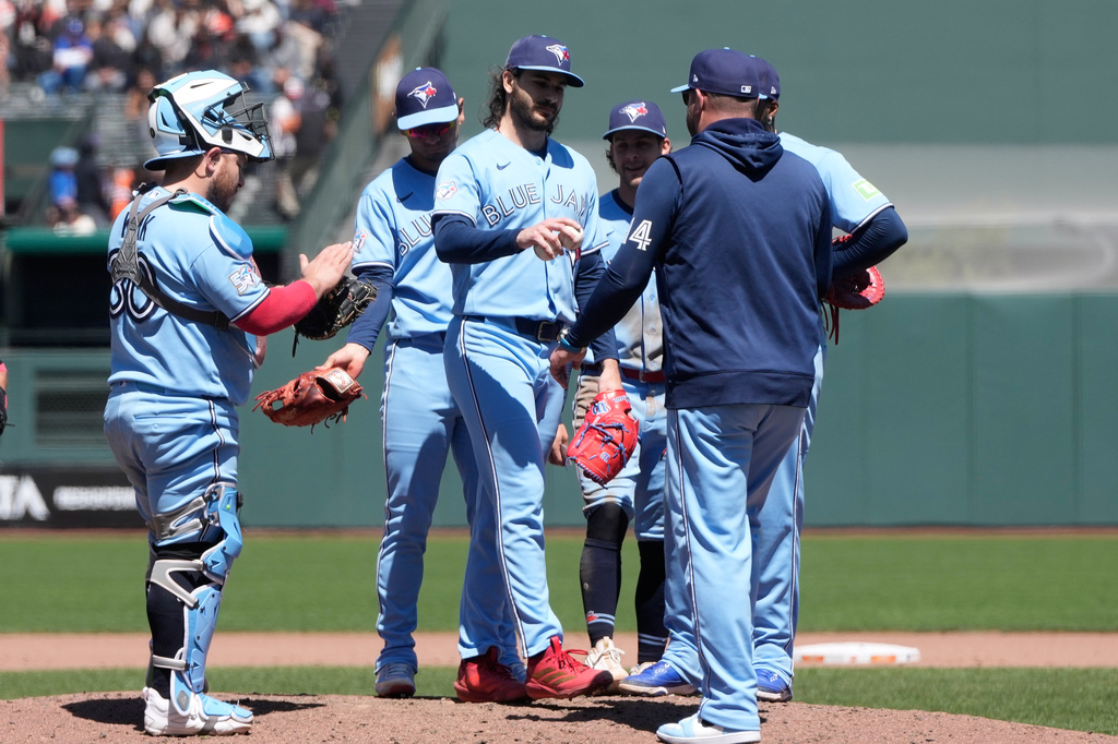 Toronto Blue Jays pitcher Dylan Cease, middle, hands the ball to manager John Schneider during a pitching change in the ninth inning of a baseball game against the San Francisco Giants Wednesday, July 8, 2026, in San Francisco. (AP Photo/Jeff Chiu)