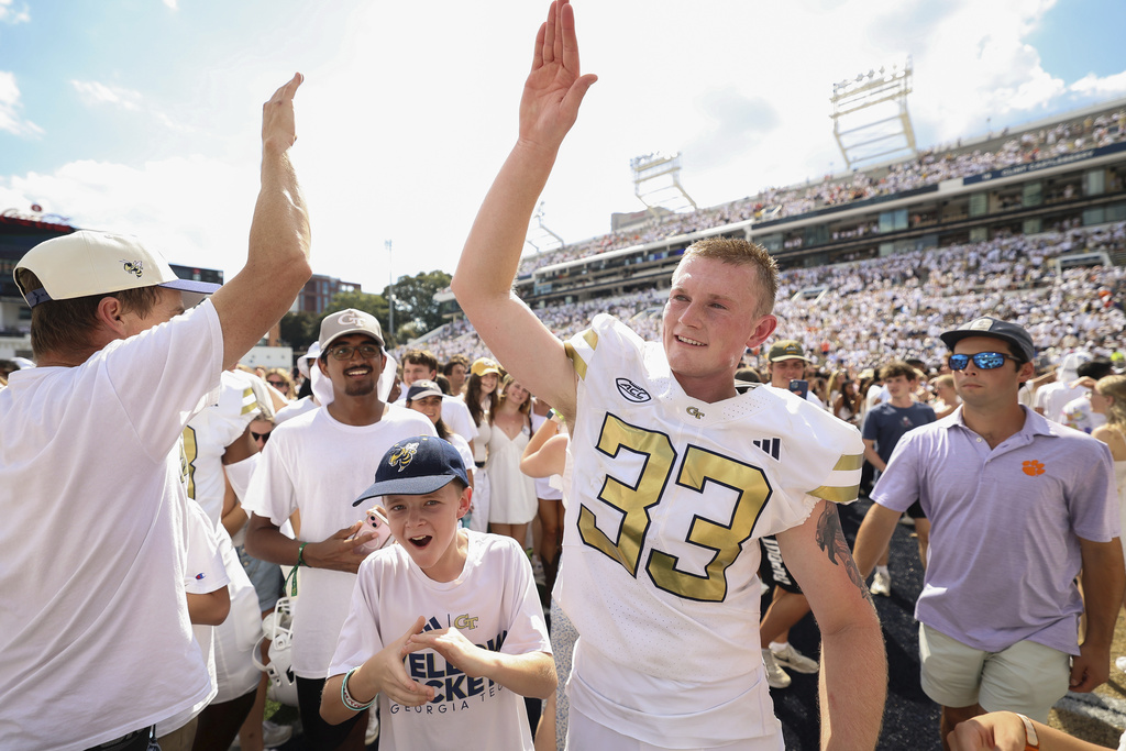 Georgia Tech place kicker Aidan Birr (33) gets ready to high-five a fan after kicking a game-winning field goal in the closing seconds of the second half of an NCAA college football game against Clemson, Saturday, Sept. 13, 2025, in Atlanta. (AP Photo/Colin Hubbard)
