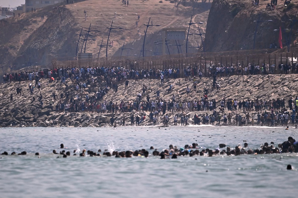 Migrants cross from Morocco into the Spanish enclave of Ceuta, Thursday, July 30, 2026. (AP Photo/Antonio Sempere)