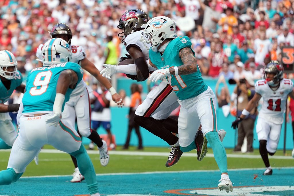 Tampa Bay Buccaneers wide receiver Chris Godwin Jr. (14) makes a catch for a touchdown against Miami Dolphins safety Ashtyn Davis (21) during the first half of an NFL football game Sunday, Dec. 28, 2025, in Miami Gardens, Fla. (AP Photo/Rebecca Blackwell)