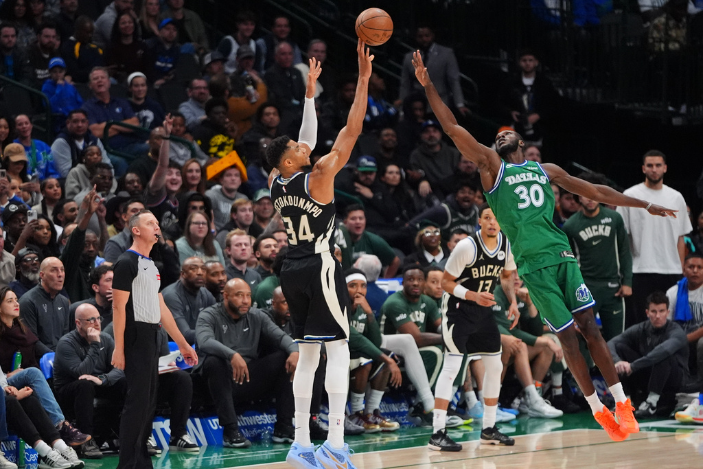 Milwaukee Bucks forward Giannis Antetokounmpo (34) shoots a three-pointer against Dallas Mavericks center Moussa Cisse (30) during the second half of an NBA basketball game in Dallas, Monday, Nov. 10, 2025. (AP Photo/LM Otero)