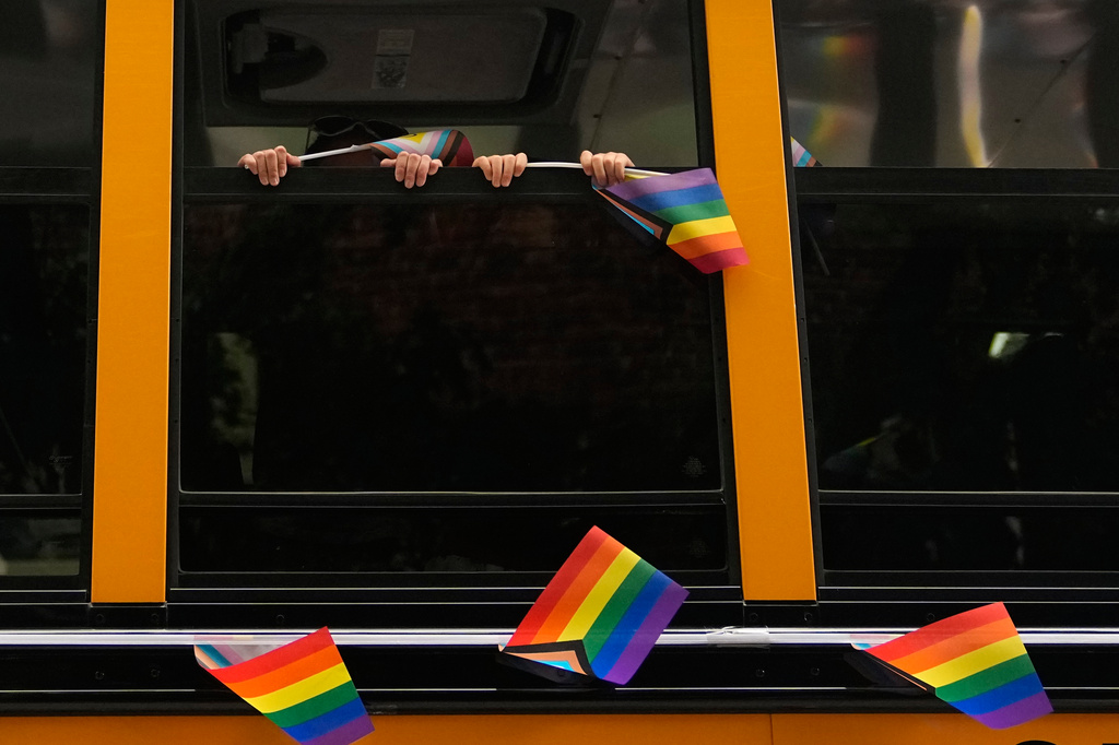 Children hold pride flags as a school bus with Seattle Public Schools drives by during the Seattle Pride Parade, Sunday, June 28, 2026, in Seattle. (AP Photo/Lindsey Wasson)
