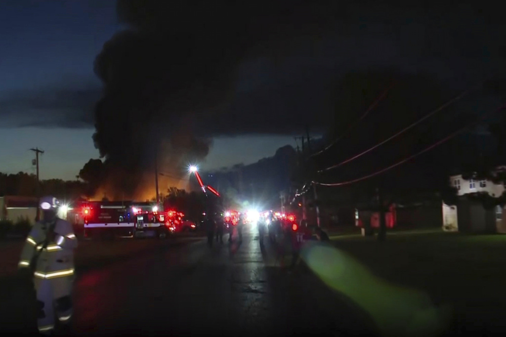 This image taken from video provided by WTVG shows firefighters working on the scene after an explosion at an industrial recycling business in Toledo, Ohio, Tuesday, Aug. 18, 2026. (WTVG via AP)