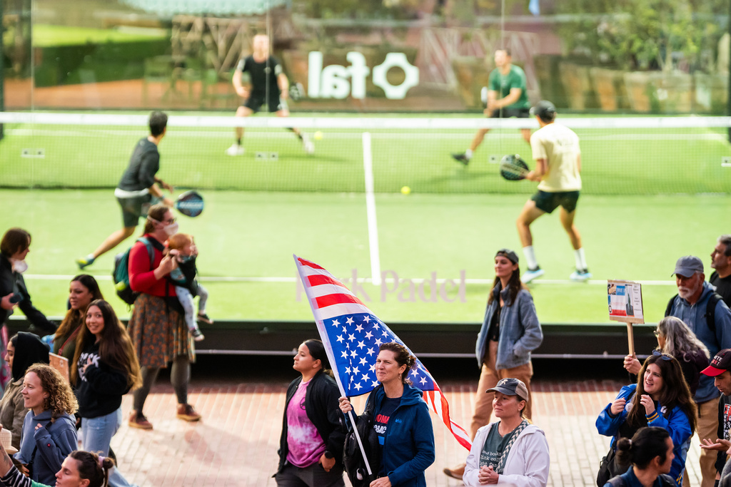 Protesters against immigration raids pass padel players in San Francisco on Thursday, Oct. 23, 2025. (AP Photo/Noah Berger)