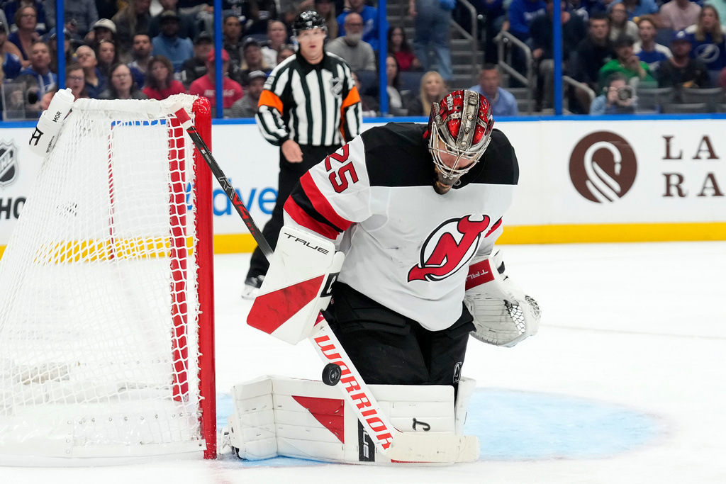 New Jersey Devils goaltender Jacob Markstrom (25) makes a save on a shot by the Tampa Bay Lightning during the second period of an NHL hockey game Saturday, Oct. 11, 2025, in Tampa, Fla. (AP Photo/Chris O'Meara)