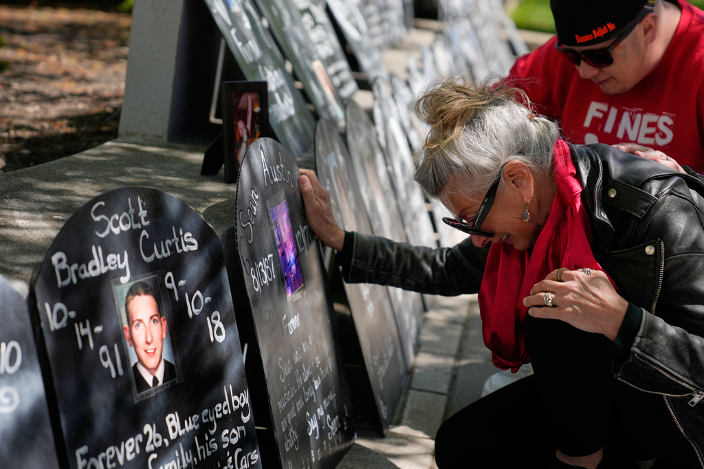 Tanny Austin cries while looking at tombstones with the names of victims of the opioid crisis, including her son Sean Austin, during a rally outside of a courthouse in Newark, N.J., Tuesday, April 21, 2026. (AP Photo/Seth Wenig)