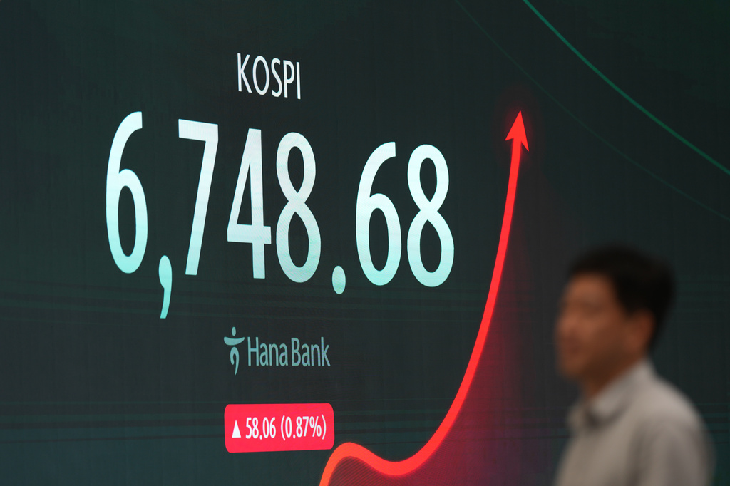 A dealer walks past near the screen showing the Korea Composite Stock Price Index (KOSPI) at a dealing room of Hana Bank in Seoul, South Korea, Monday, July 27, 2026. (AP Photo/Lee Jin-man)