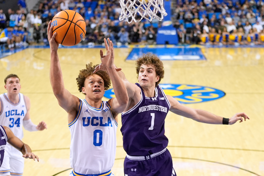 UCLA guard Trent Perry, left, shoots as Northwestern forward Tyler Kropp defends during the first half of an NCAA college basketball game, Saturday, Jan. 24, 2026, in Los Angeles. (AP Photo/Mark J. Terrill)