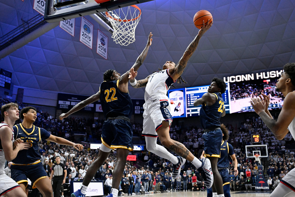 UConn guard Solo Ball (1) shoots as New Haven guard Maison Adeleye (22) defends during the first half of an NCAA college basketball game, Monday, Nov. 3, 2025, in Storrs, Conn. (AP Photo/Jessica Hill)