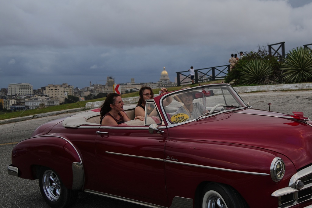 Tourists take a ride in a classic American car in Havana, Monday, Jan. 26, 2026. (AP Photo/Ramon Espinosa)