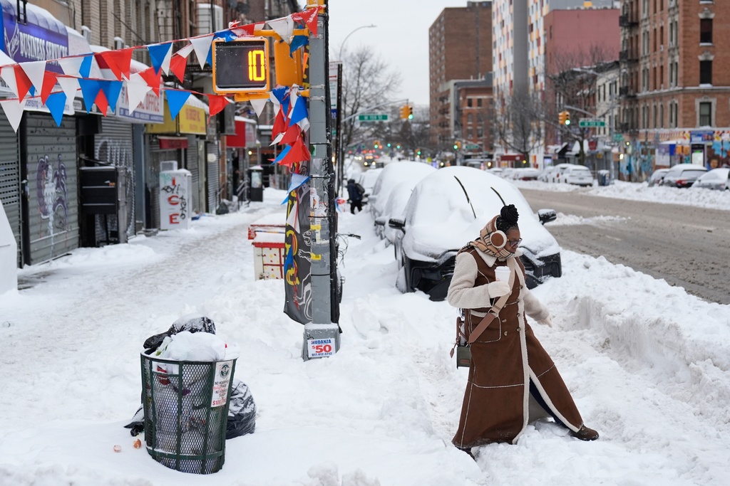 FILE - Carrie Hampton tries to navigate a snowy intersection without spilling her coffee in New York, Jan. 26, 2026. (AP Photo/Seth Wenig, File)