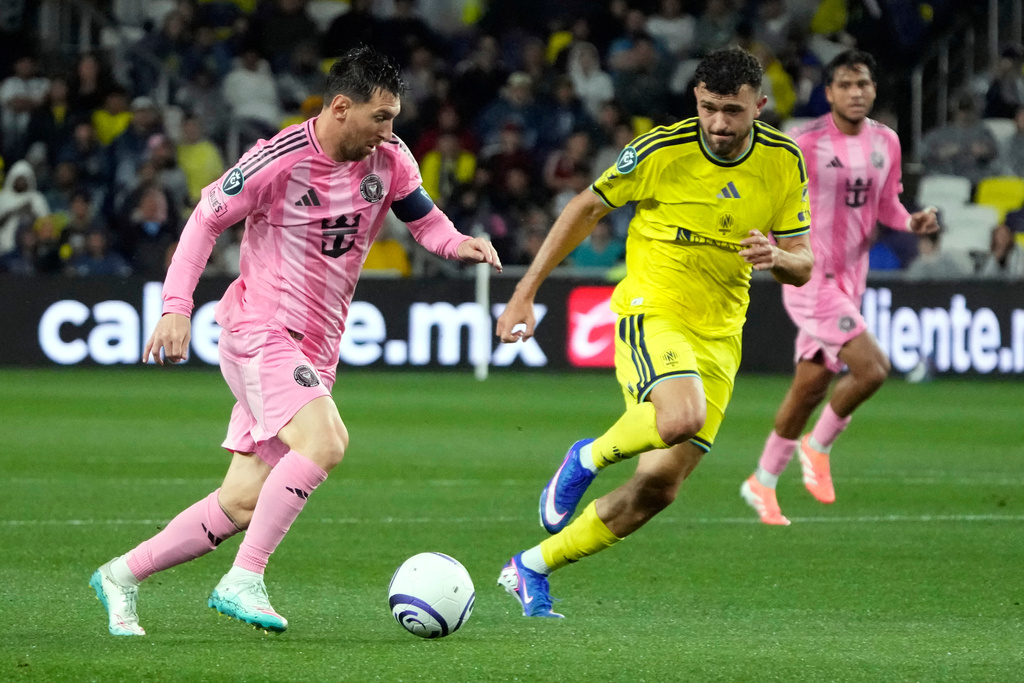 Inter Miami forward Lionel Messi, left, moves the ball against Nashville SC midfielder Patrick Yazbek in the first half of a CONCACAF Champions Cup Round of 16 soccer match Wednesday, March 11, 2026, in Nashville, Tenn. (AP Photo/Mark Humphrey)