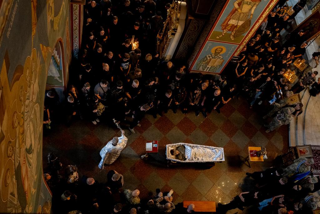 Relatives and friends mourn near the coffin of Ukrainian serviceman Danyil Smyrnov, 21, who was killed on the frontline, during the funeral ceremony in Kyiv, Ukraine, Thursday, Sept. 3, 2026. (AP Photo/Alex Babenko)