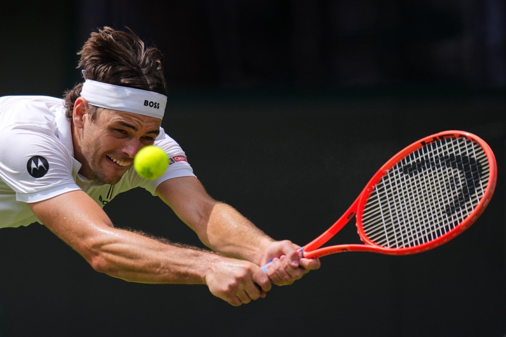 Taylor Fritz of the United States returns the ball to Dusan Lajovic of Serbia in their first round men's singles match at the Wimbledon Tennis Championships in London, Tuesday, June 30, 2026. (AP Photo/Kirsty Wigglesworth)