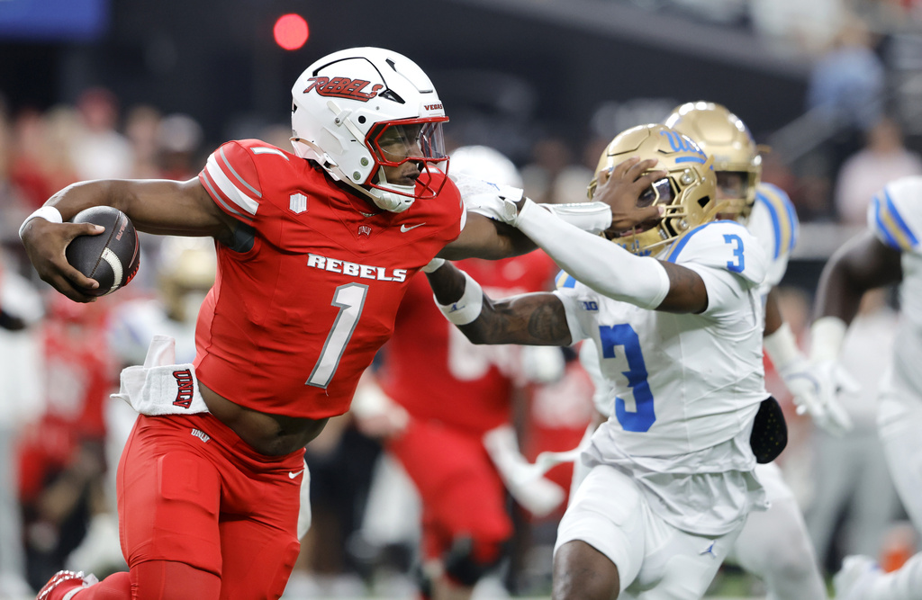 UNLV quarterback Alex Orji (1) stiff-arms UCLA defensive back Robert Stafford III (3) during the first half of an NCAA college football game Saturday, Sept. 6, 2025, in Las Vegas. (Steve Marcus/Las Vegas Sun via AP)