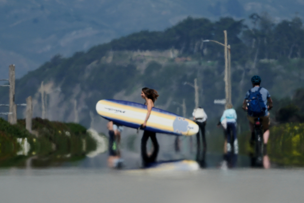Heat waves from the road rise as people walk along The Great Highway in San Francisco, Tuesday, March 17, 2026. (AP Photo/Jeff Chiu)