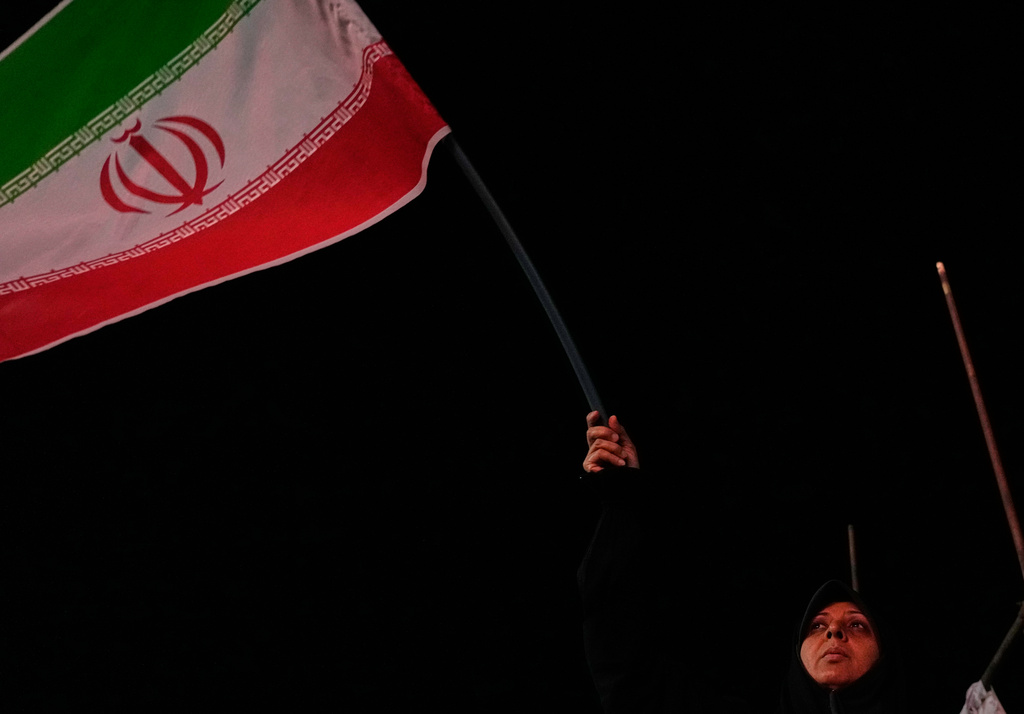 An Iranian pro-government demonstrator waves her country's flag in a gathering at a square in Tehran, Iran, Tuesday, July 28, 2026. (AP Photo/Vahid Salemi)