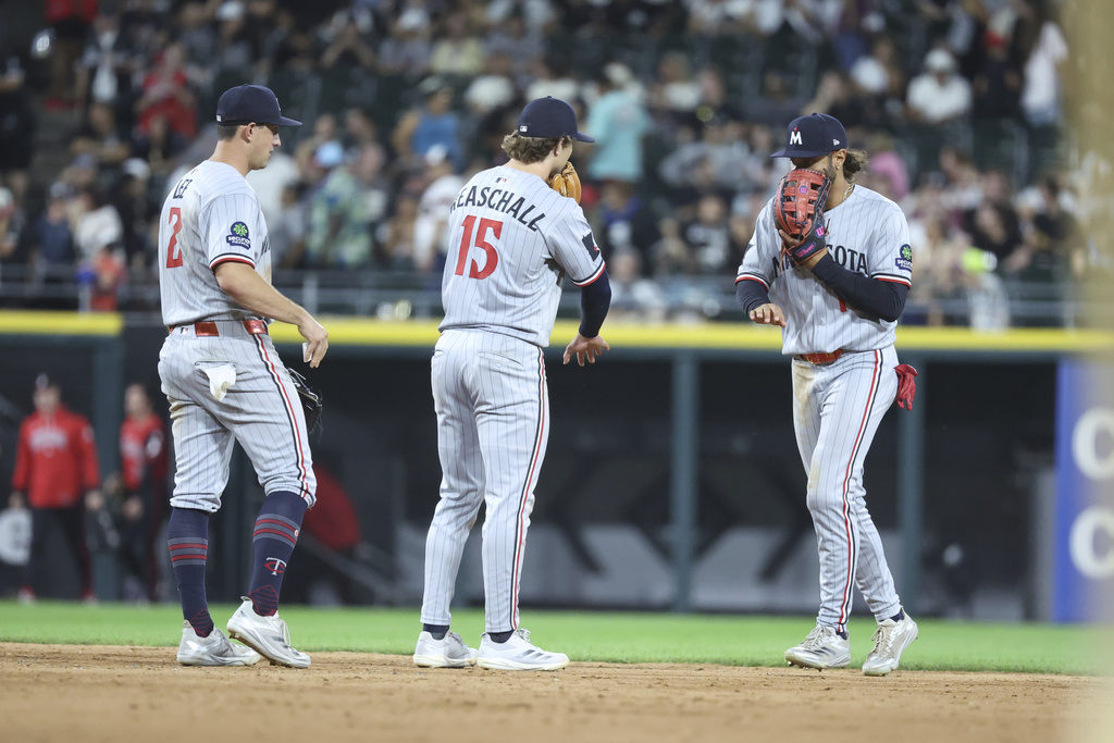 Minnesota Twins shortstop Brooks Lee (2), second baseman Luke Keaschall (15) and outfielder Austin Martin, right, celebrate after their team's win over the Chicago White Sox in a baseball game, Friday, Aug. 22, 2025, in Chicago. (AP Photo/Talia Sprague)