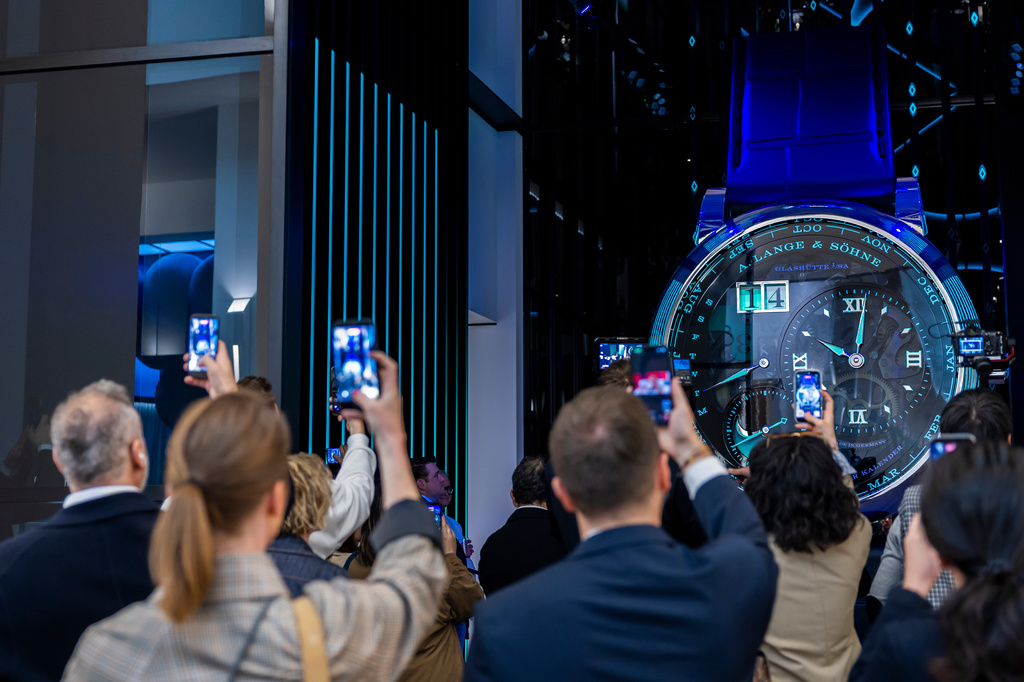 Visitors take photos with their smartphones of a watch at the German watch manufacturer A. Lange & Shone stand, during the opening day of the "Watches and Wonders Geneva" luxury watch fair, in Geneva, Switzerland, Tuesday, April 14, 2026. (Salvatore Di Nolfi/Keystone via AP)