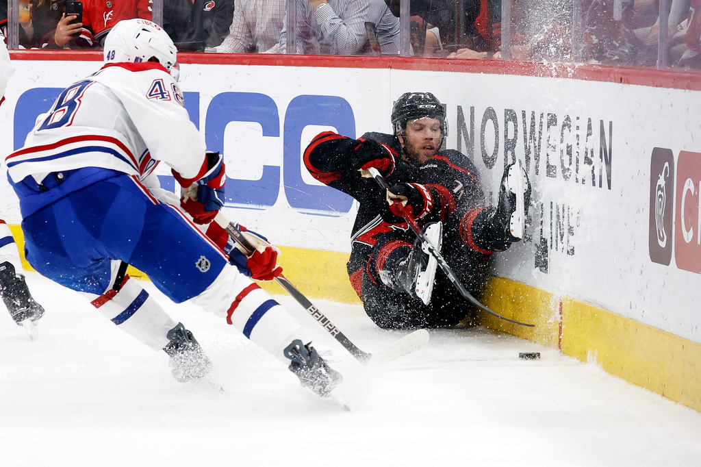 Carolina Hurricanes' Taylor Hall (71) crashes into the boards with Montréal Canadiens' Lane Hutson (48) nearby during the second period in Game 1 of the Eastern Conference finals NHL hockey Stanley Cup playoffs series in Raleigh, N.C., Thursday, May 21, 2026. (AP Photo/Karl DeBlaker)