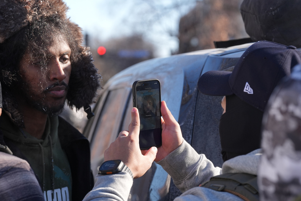 ADDS REFERENCE TO FACIAL RECOGNITION APP - Federal agents use a facial recognition app on a person detained and who later released on Tuesday, Jan. 27, 2026, in Minneapolis. (AP Photo/Adam Gray)