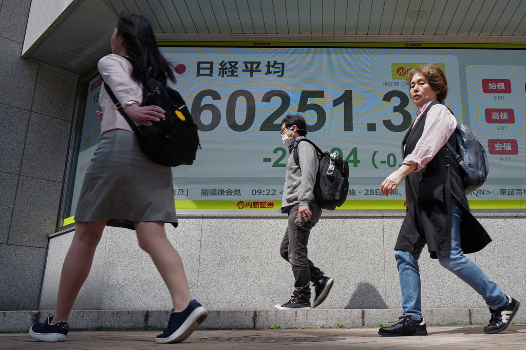 People past an electronic stock board showing Japan's Nikkei index at a securities firm Tuesday, April 28, 2026, in Tokyo. (AP Photo/Eugene Hoshiko)