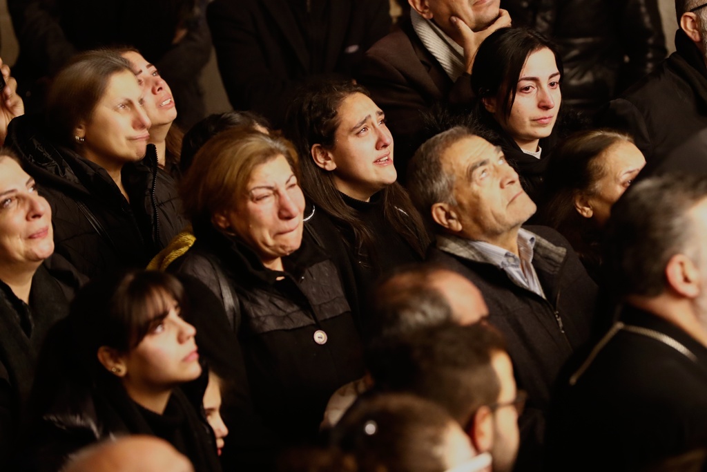 People react as they attend the lighting of a Christmas tree at the Greek Orthodox Mar Elias Church, months after the church was the site of a deadly suicide bombing, in the Dweila neighborhood of Damascus, Syria, Tuesday, Dec. 23, 2025.(AP Photo/Omar Sanadiki)