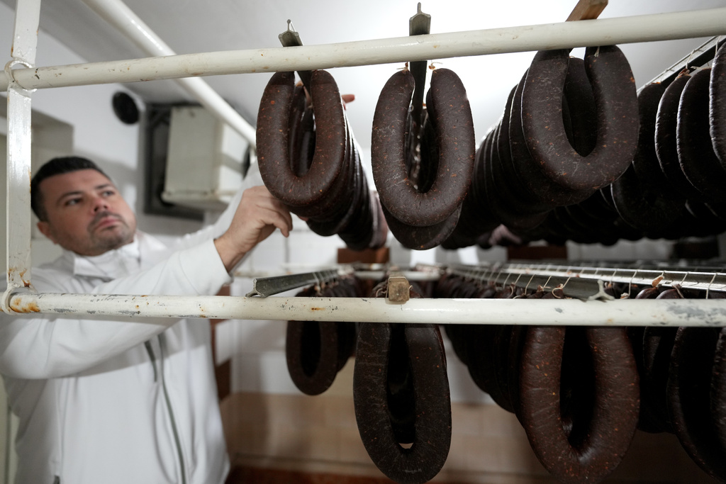 Misa Rajic hangs ironed sausages at his home in Pirot, Serbia, on Feb. 13, 2026. (AP Photo/Darko Vojinovic)