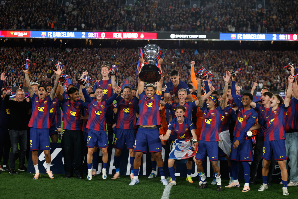Barcelona players lift the trophy after winning the Spanish La Liga soccer match against Real Madrid to clinch the Spanish league title in Barcelona, Spain, Sunday, May 10, 2026. (AP Photo/Joan Monfort)