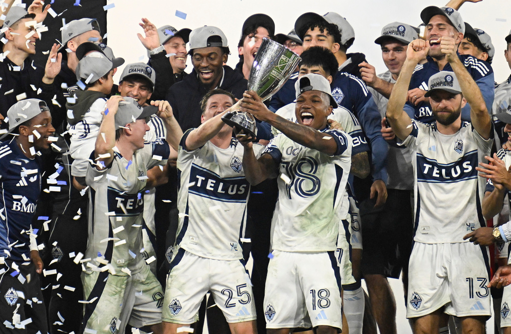 Vancouver Whitecaps midfielder Ryan Gauld (25) and defender Édier Ocampo (18) hold up the trophy after winning the MLS Western Conference final soccer match against San Diego FC, Saturday, Nov. 29, 2025, in San Diego. (AP Photo/Denis Poroy)