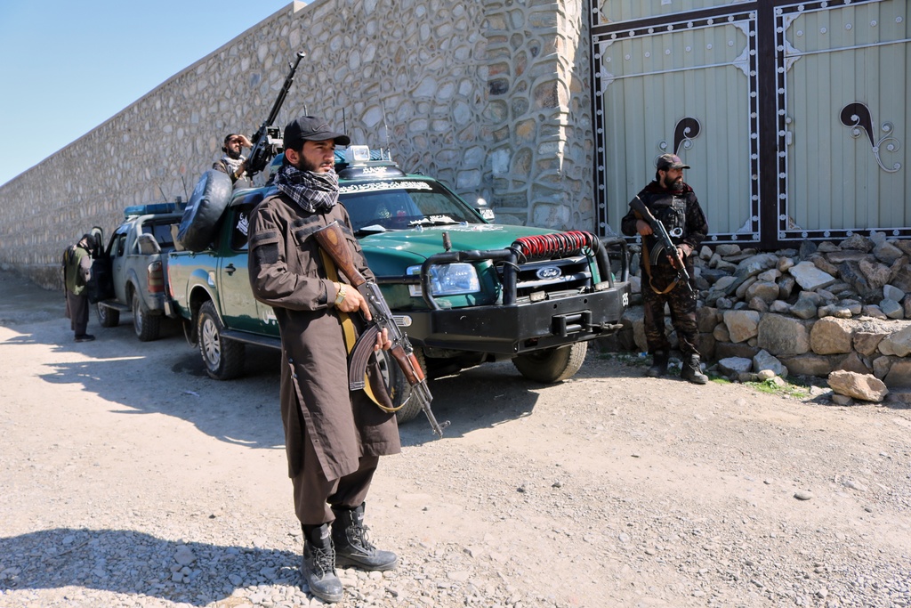 Taliban police guard the area where a strike hit a house in the Momand Dara district of Nangarhar province, Afghanistan, near the border with Pakistan, Friday, March 13, 2026. (AP Photo/Hedayat Shah)