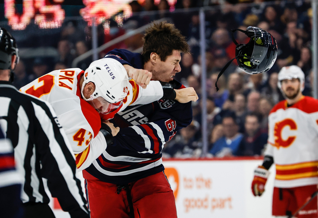 Winnipeg Jets' Logan Stanley (right) and Calgary Flames' Adam Klapka (43) fight during first period NHL action in Winnipeg on Friday, Oct. 24, 2025. (John Woods/The Canadian Press via AP)