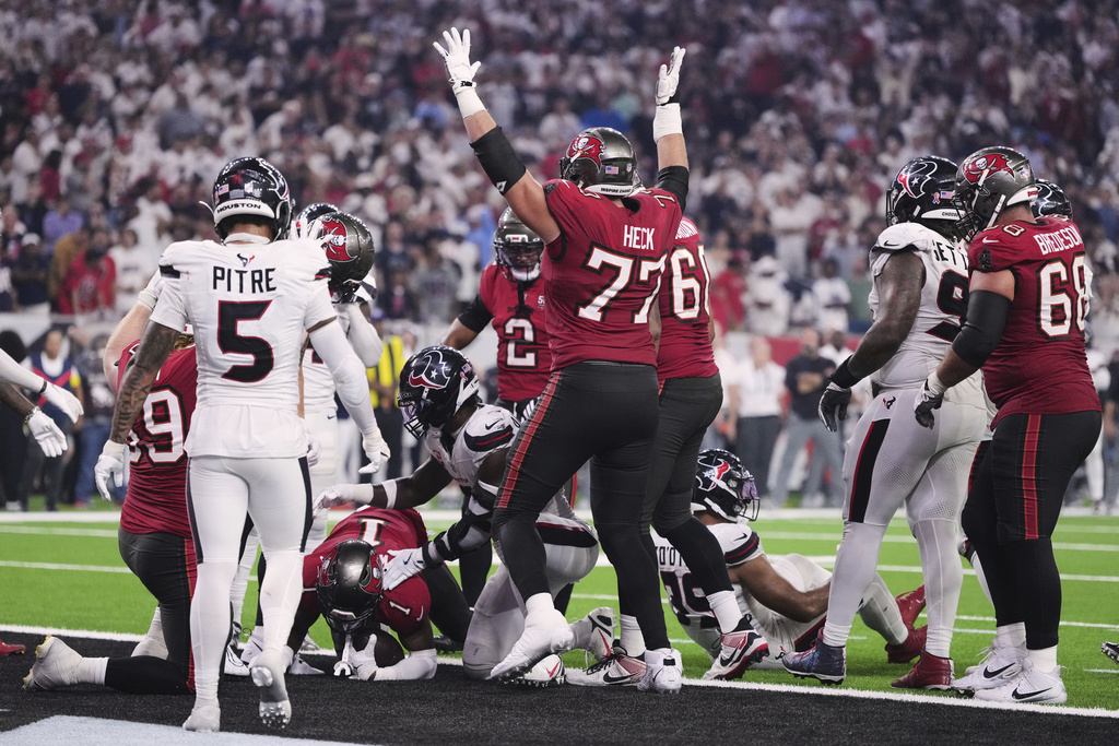Tampa Bay Buccaneers offensive tackle Charlie Heck (77) celebrates a touchdown run by running back Rachaad White (1) as Houston Texans safety Jalen Pitre (5) and others look on in the second half of an NFL football game Monday, Sept. 15, 2025, in Houston, Texas. (AP Photo/Eric Gay)