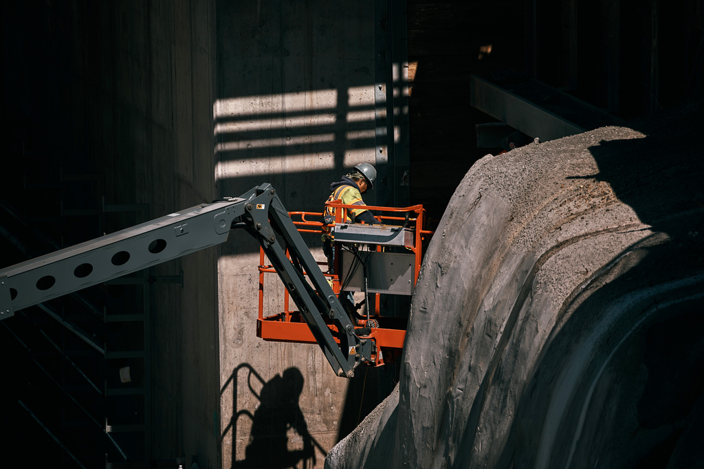 A worker stands on a crane while securing exposed rock along a wall at the Palisades Tunnel Project, part of the Gateway Program, on Tuesday, May 12, 2026, in North Bergen, N.J. (AP Photo/Andres Kudacki)