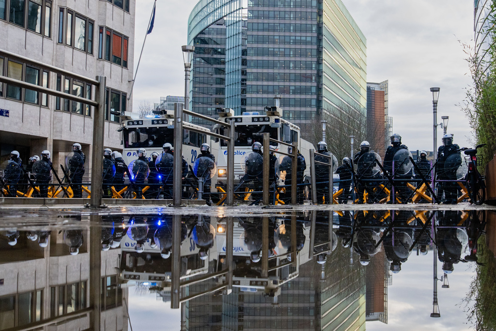 Police stand behind a barrier as European farmers block a road with their tractors during a demonstration outside the EU Summit in Brussels, Thursday, Dec. 18, 2025. (AP Photo/Marius Burgelman)