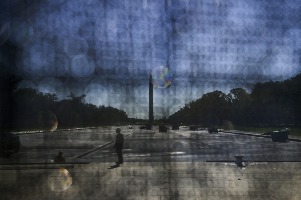 The Washington Monument is seen through a tarp as work continues near the Lincoln Memorial Reflecting Pool ahead of the United States' 250th anniversary, Thursday, June 4, 2026 in Washington. (AP Photo/Rod Lamkey, Jr.)